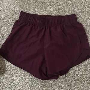 Athletic maroon shorts with cute mesh trim.